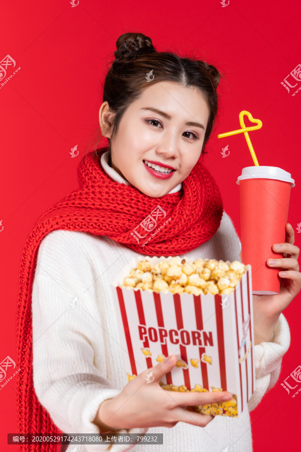 拿着爆米花和饮料的快乐女子