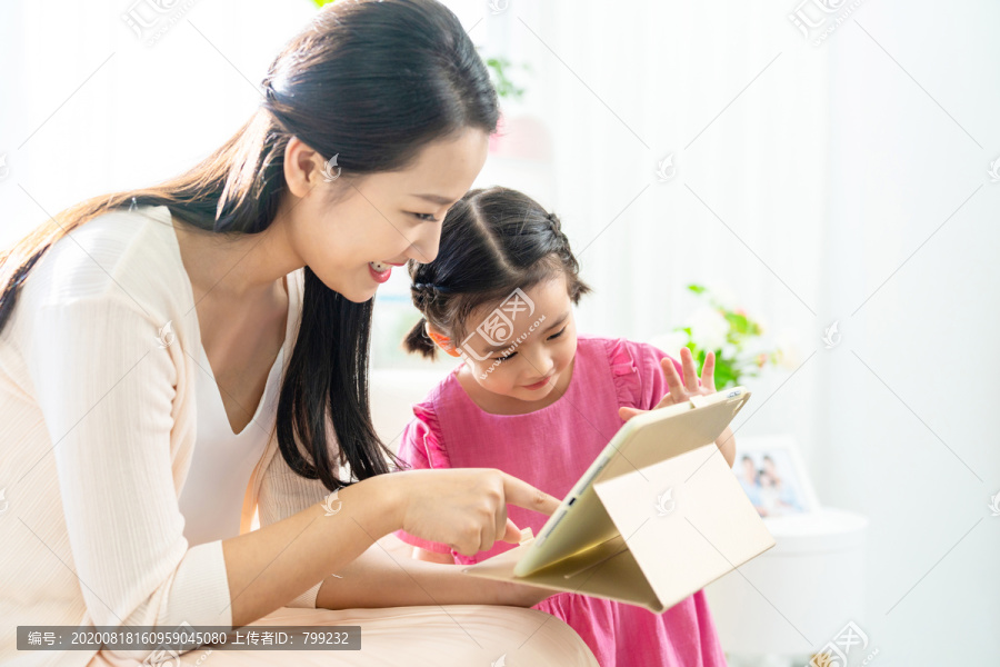 小女孩和妈妈一起使用平板电脑