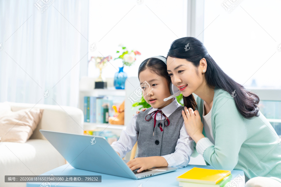 小女孩和妈妈一起使用笔记本电脑