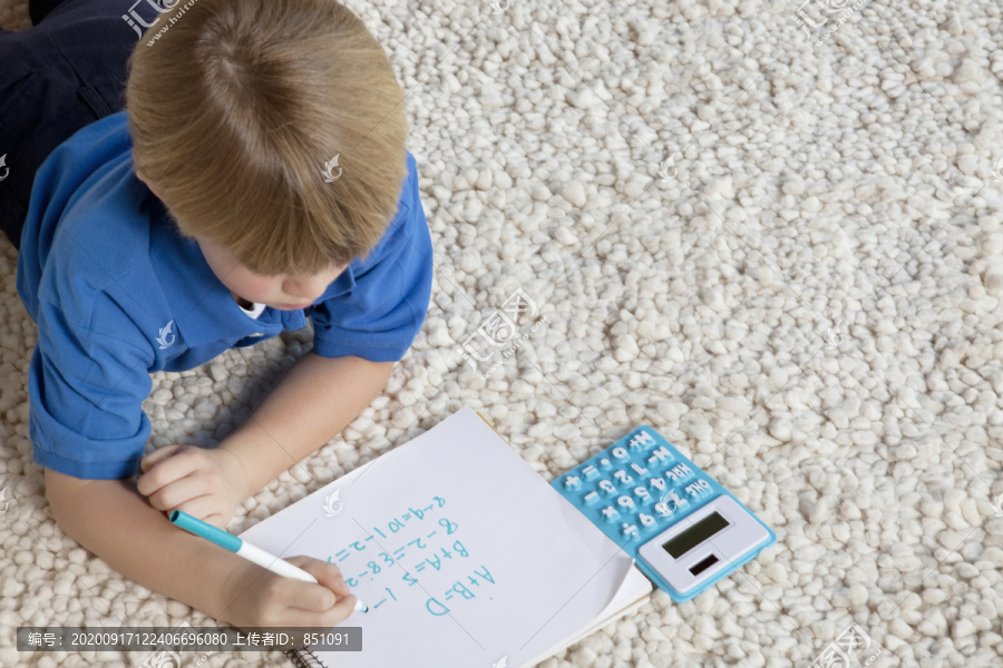 地毯上做作业的小男孩