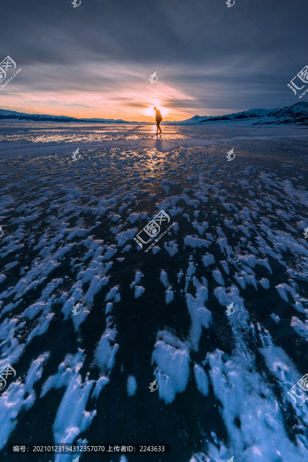 游客在冰雪赛里木湖的日落