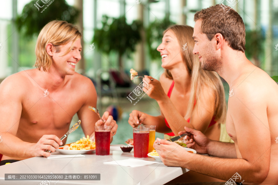 三个年轻人，一女两男，在一个公共游泳池的餐厅里吃喝