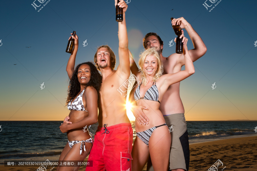 人们（两对情侣）在海滩上开派对，在夕阳下喝酒，玩得很开心（人们手里拿着瓶子）
