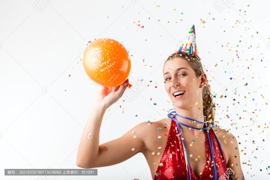 带着气球和微笑在五彩纸屑淋浴间庆祝生日的女人