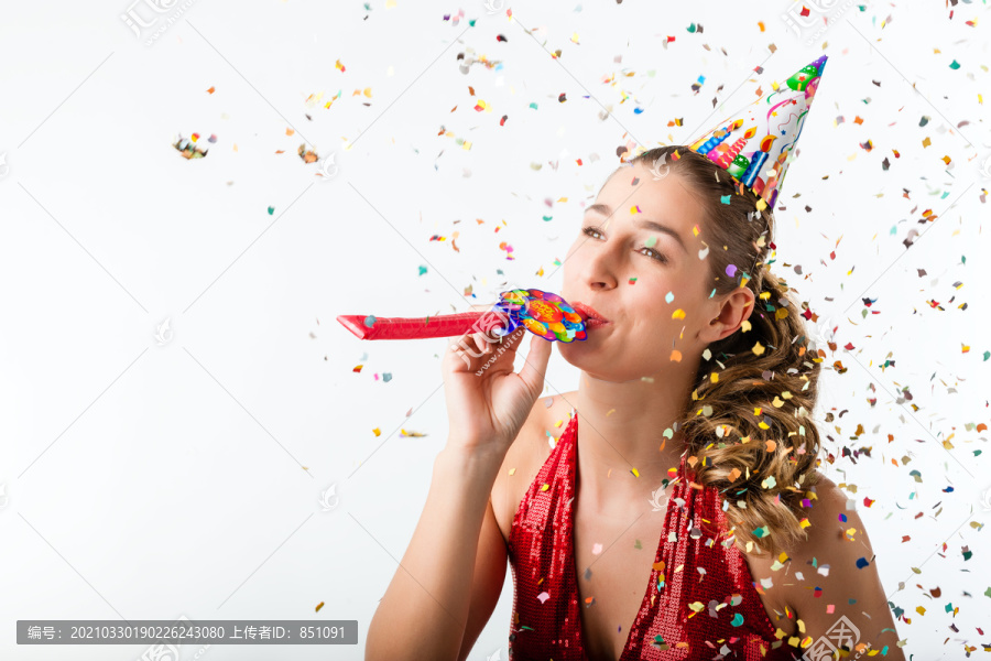 庆祝生日的女人在五彩纸屑旁用喇叭鸣叫