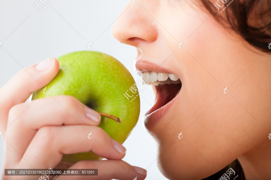 健康的营养和健康的牙齿或饮食，年轻女子咬在一个新鲜的苹果