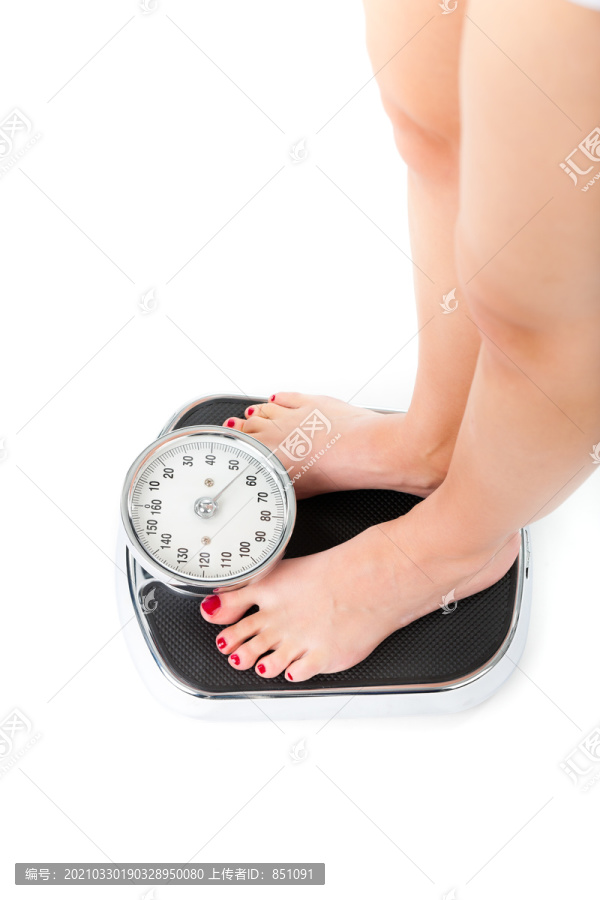 饮食和体重，年轻女子站在秤上，只看到脚