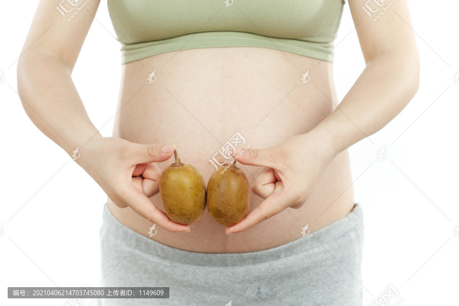 年轻孕妇手上拿着两个猕猴桃