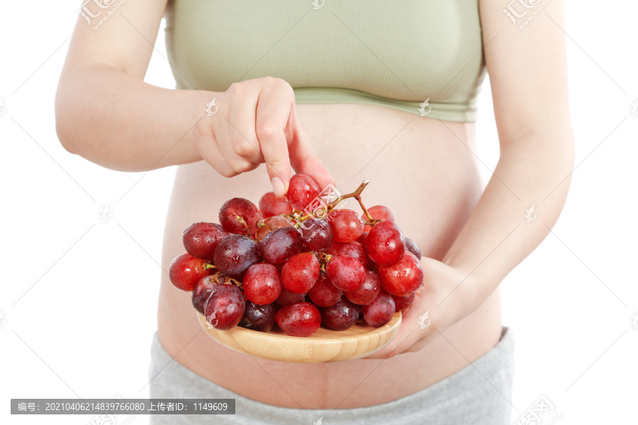 年轻女人手上端着一盘红提葡萄