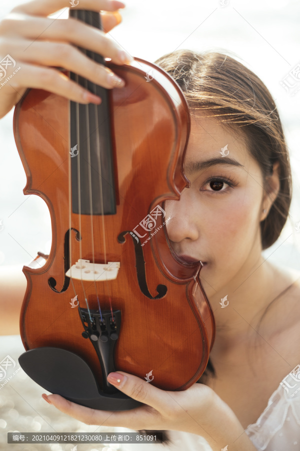剪短的小提琴图像，美丽的女人抬起半张脸。