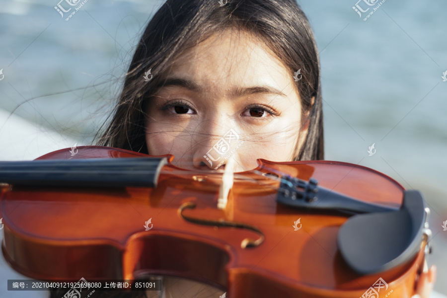 黑发女子用小提琴捂住嘴。