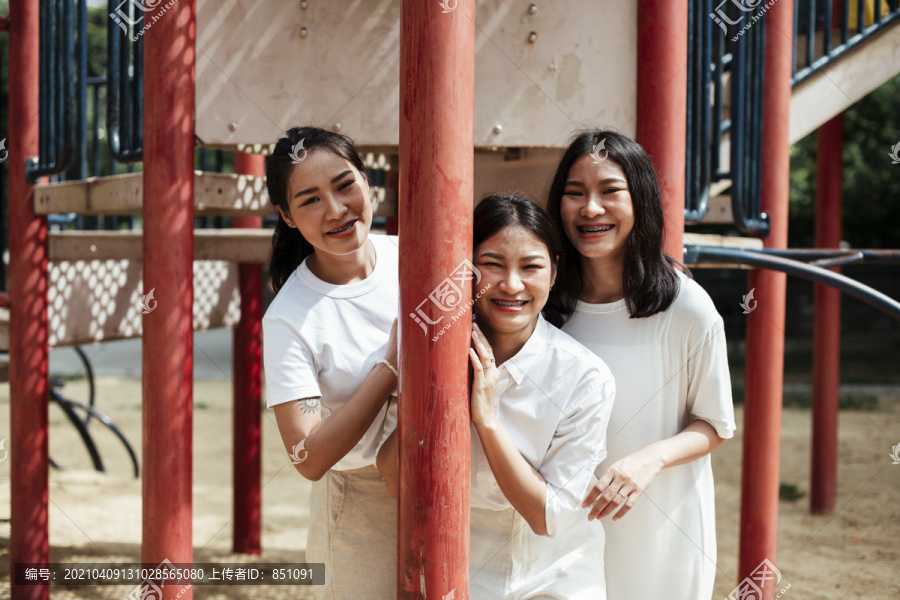三对双胞胎妹妹在公园操场上玩东西的红杆子上开心。