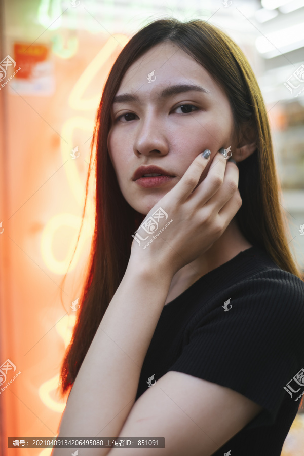 特写时尚肖像-美丽的时髦亚洲年轻女子在霓虹灯背景黑色衬衫。