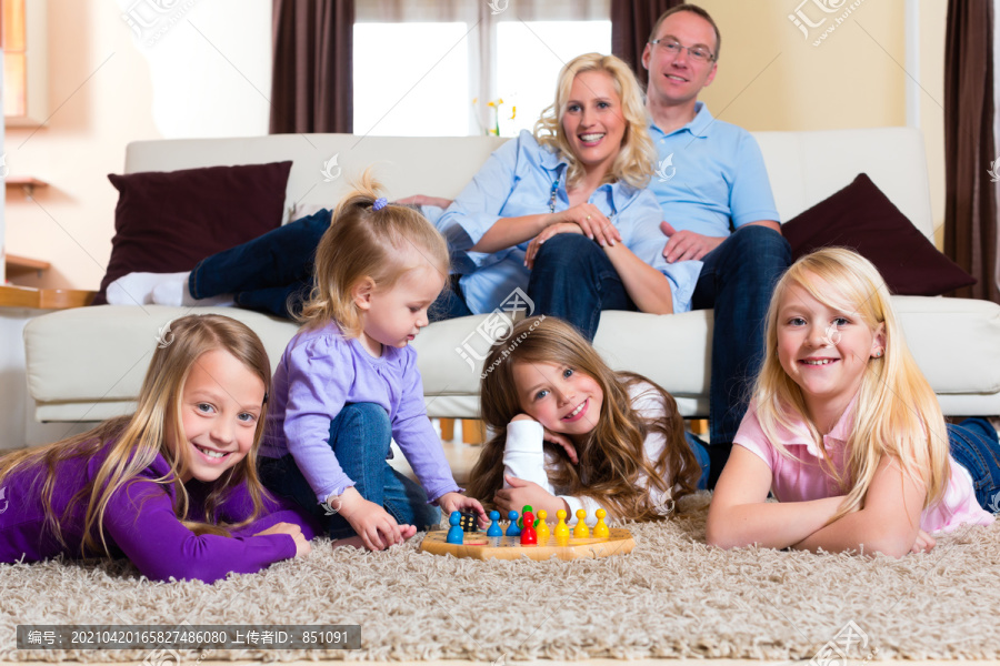 一家人在家的地板上玩桌游