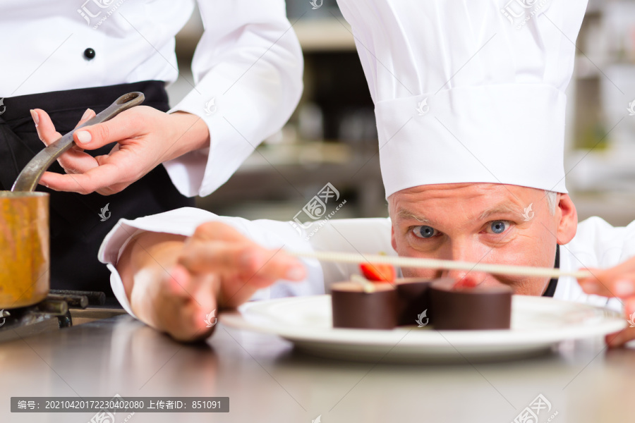 厨师，糕点厨师，在酒店或餐厅的厨房烹饪时，他正在整理甜点