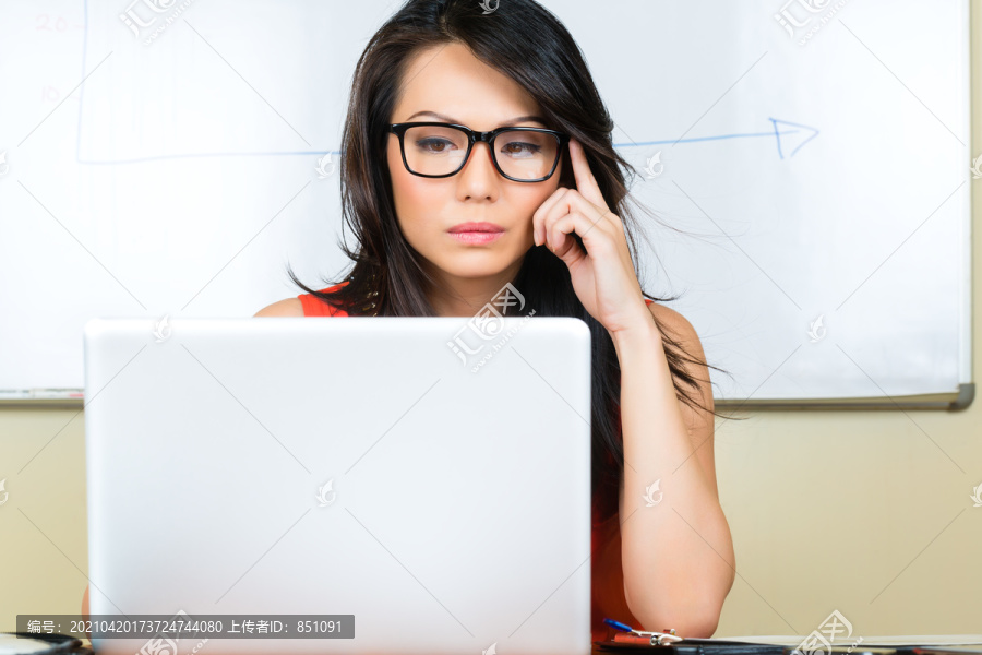 亚洲创意机构-坐在笔记本电脑上的中国女商人