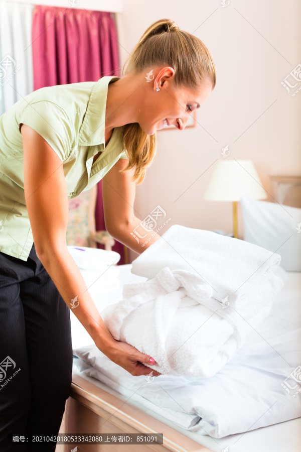 服务员在旅馆做客房服务，她正在整理床铺