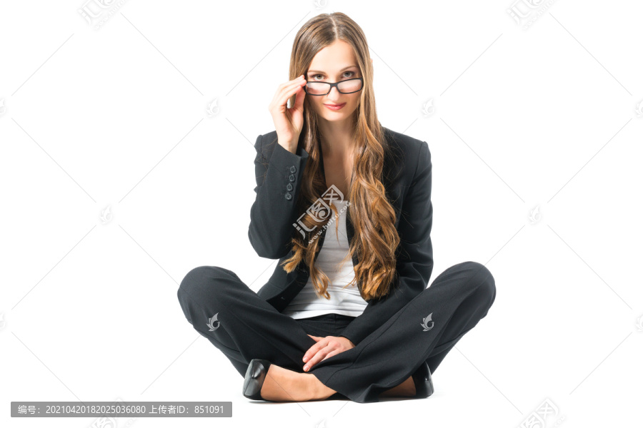 在白色背景前戴着眼镜的年轻女商人，坐在地板上，也许她是个女商人，或者是个旁观者