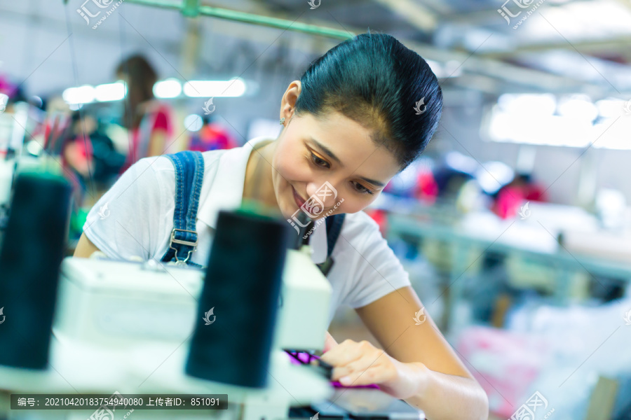 亚洲女裁缝或印尼工厂的工人用工业缝纫机缝纫，她非常准确