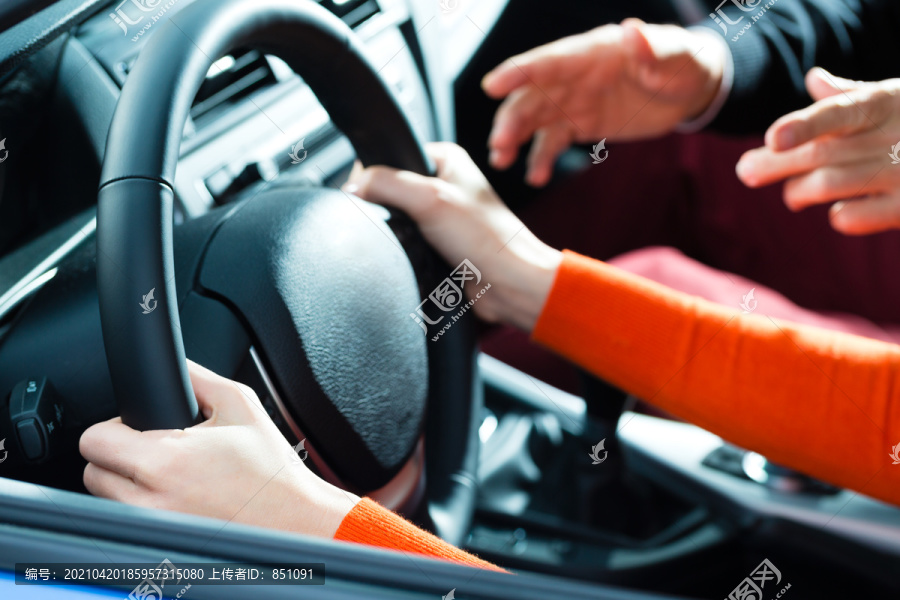 驾校——年轻女子用方向盘驾驶汽车，也许她有驾驶考试，也许她练习停车