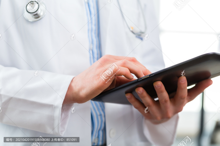 站在诊所里读平板电脑上的文件或档案的年轻医生