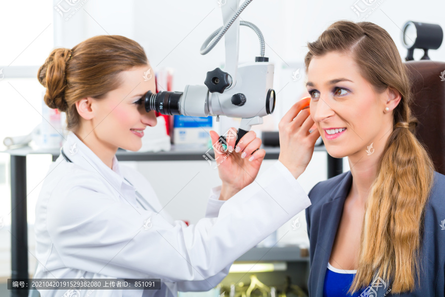 医生-年轻的女医生或耳鼻喉科专家-与患者一起在她的诊所，用内窥镜检查耳朵