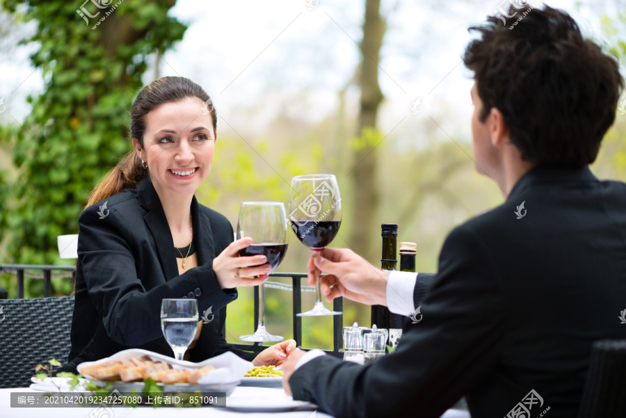 商务人士在一家高级餐厅的露台上享用商务午餐