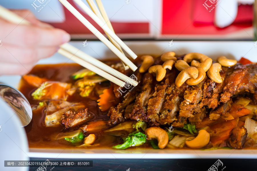 年轻人在泰国餐馆吃饭，他们用筷子吃饭，特写手和食物