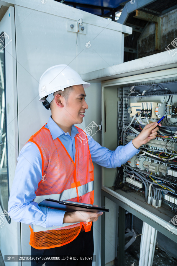 亚裔印尼技术人员或电工在施工现场或工厂对断路器箱或带电源线的开关箱进行功能试验验收