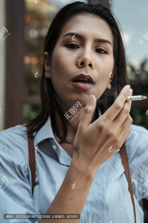 特写亚泰美女抽着烟，看起来很酷。