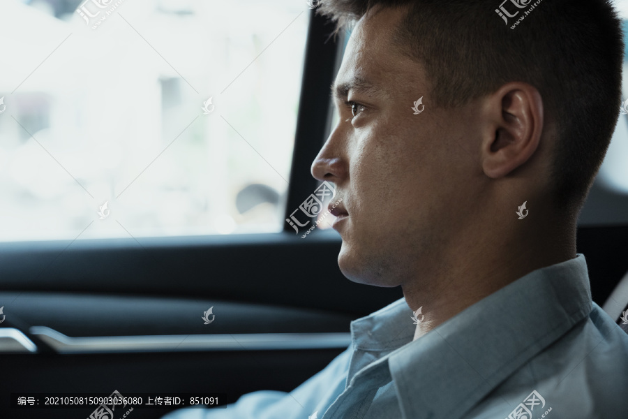商人坐在车里看前方道路的中等特写镜头。