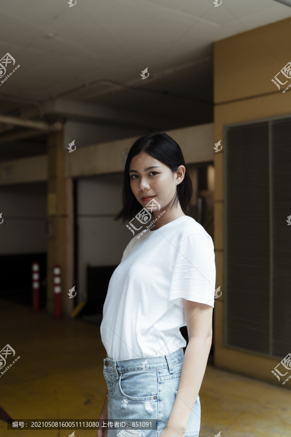 街上穿着白衬衫和短牛仔裤的泰国亚裔年轻女子。实体模型。复制空间。