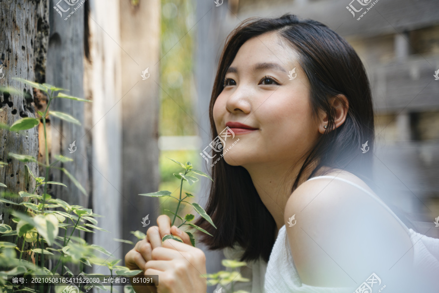 年轻美丽的亚洲女人的肖像在白色的衣服上自然。带着幸福的表情微笑。