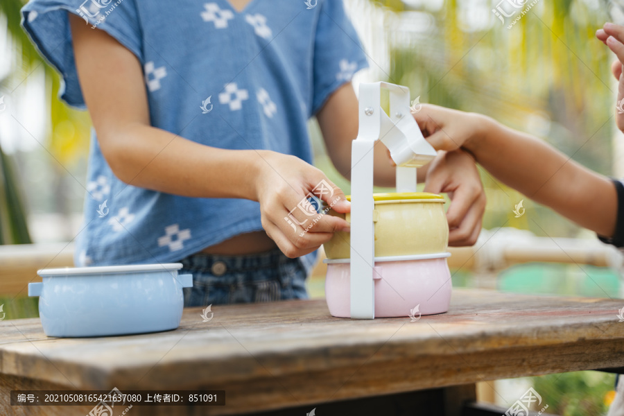 亚裔小孩的手用泰语打开食品盒或平托。午餐现场。