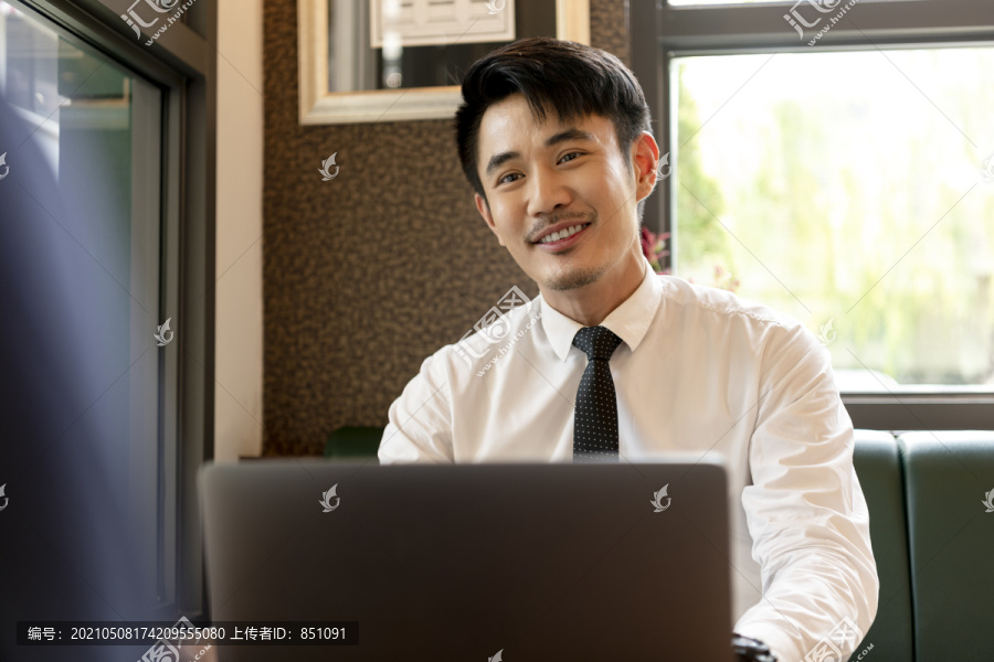 穿着白衬衫的亚裔商人用笔记本电脑面试候选人。