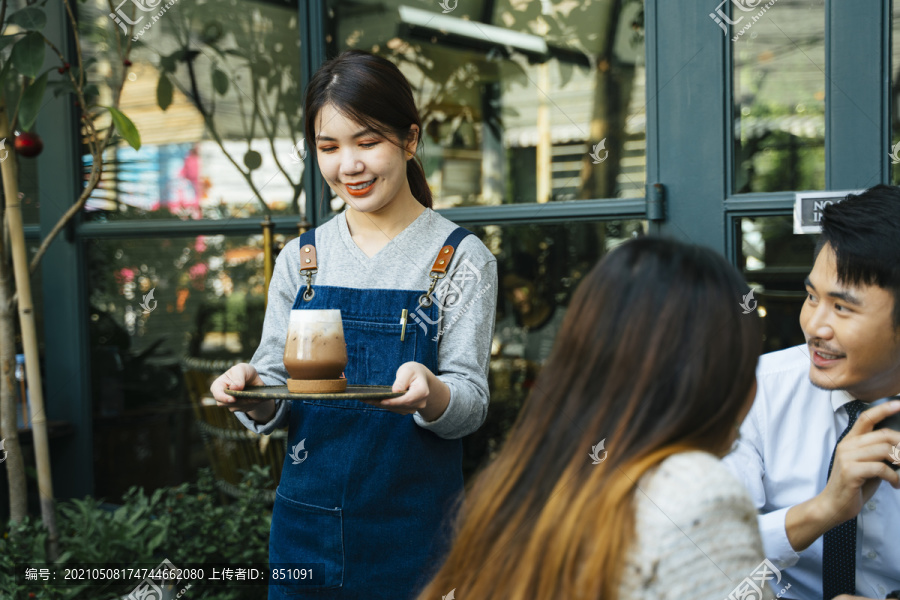 亚泰女服务员在咖啡厅为顾客提供冰镇咖啡。