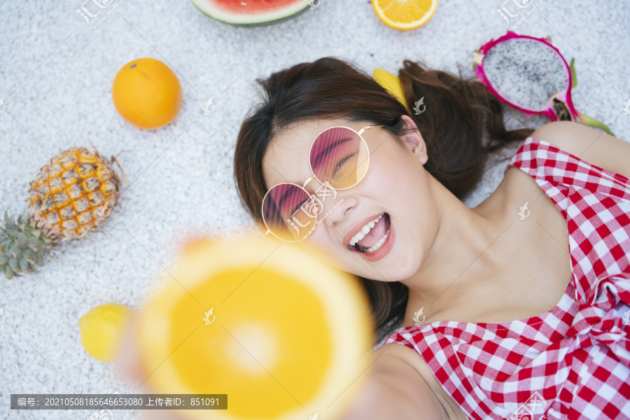 特写美丽的亚洲年轻女子手里拿着一片柠檬。热带水果。暑假。