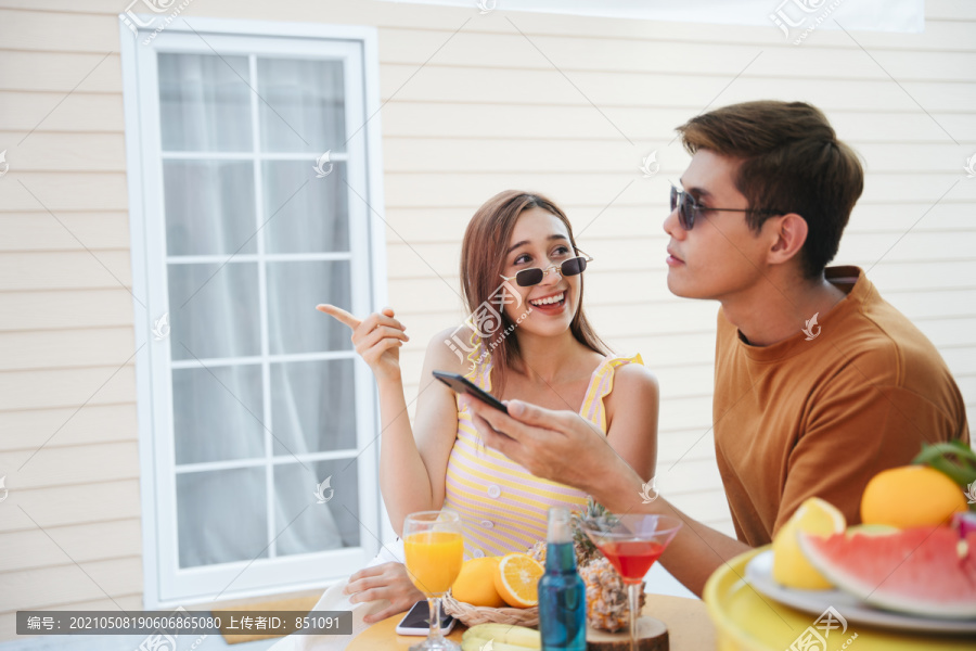 快乐的情侣们喜欢在夏天的热带酒吧里度过美好的假期。