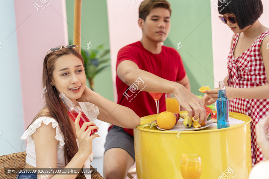 一群年轻的亚洲人在夏天的酒吧里享用热带水果和鸡尾酒。泰国的夏日派对。