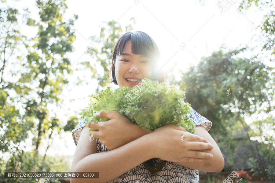 生态旅游-美丽的亚泰女子鲍勃发型手拿绿色新鲜蔬菜。蔬菜爱好者。健康食品。