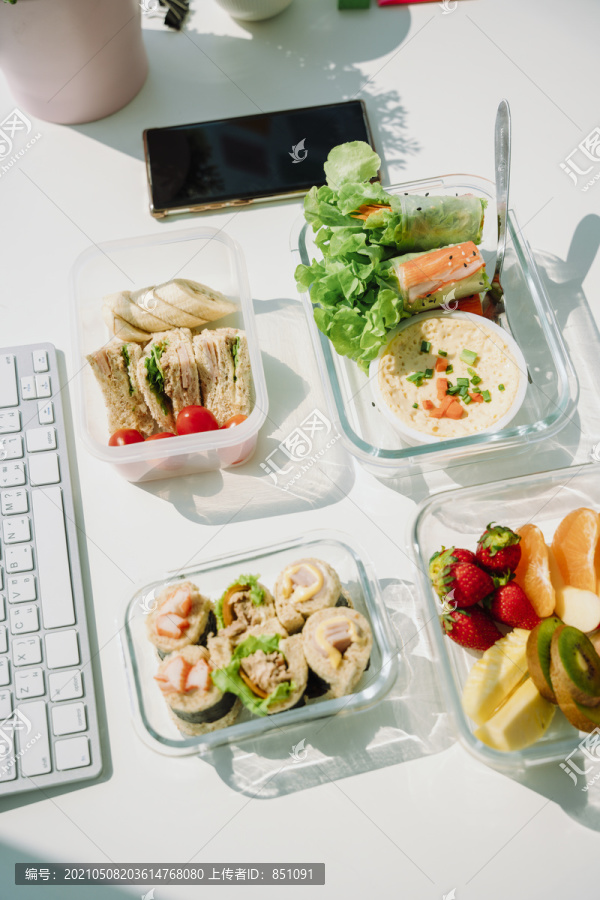 4个健康食品碗的顶视图，包括沙拉碗、春卷、三明治和水果。