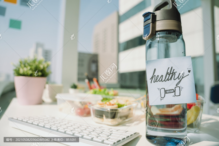 一瓶水和一个健康的午餐盒装在办公室里。