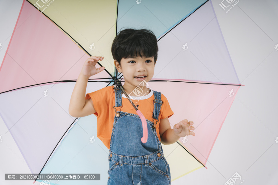 小男孩得到彩色粉彩雨伞时很高兴，他很喜欢雨伞。