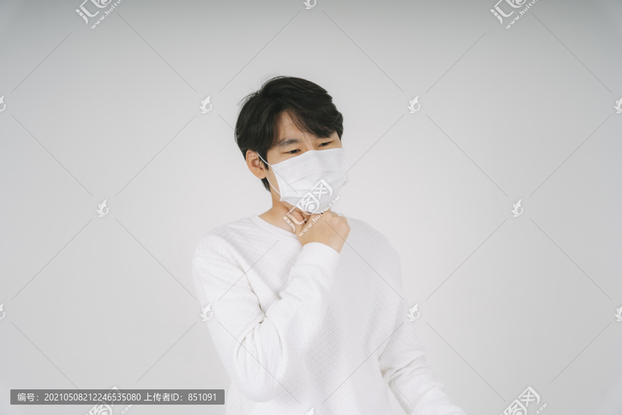 一个男人在生病的时候戴着面具，一个在摄影棚里以白色背景的孤立的人。