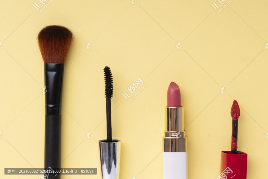 顶视图。平铺。化妆品化妆工具集合在明亮的黄色背景上。复制空间。