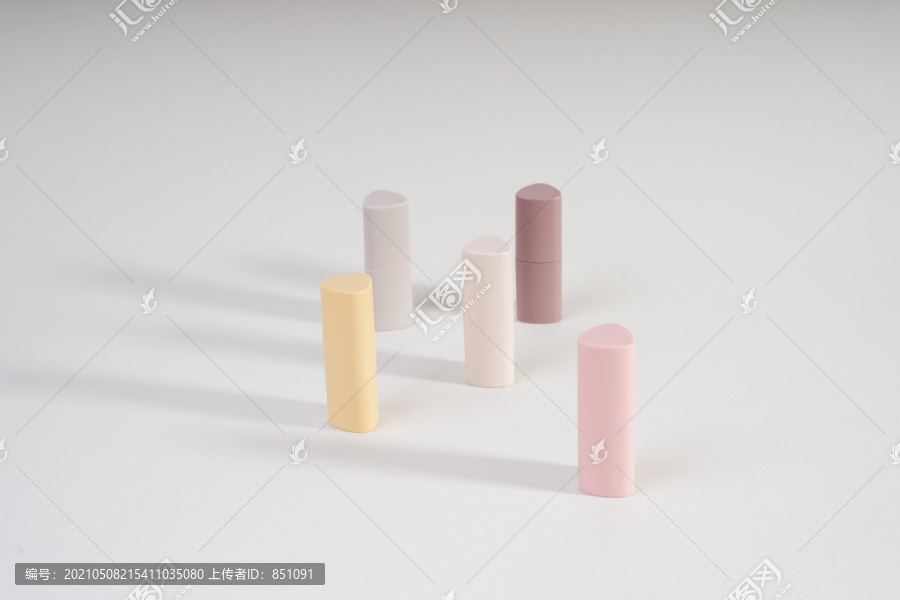 很多不同的唇膏都是以米色和粉色为背景的。美的图案和概念，化妆品，女性配饰。唇膏管的色调。