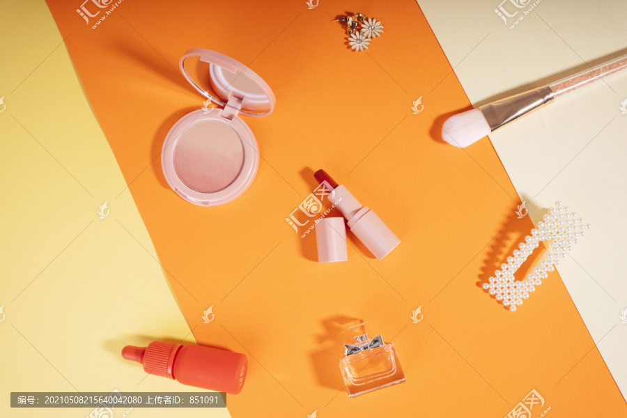 橙色背景上的女性配饰化妆品背景。
