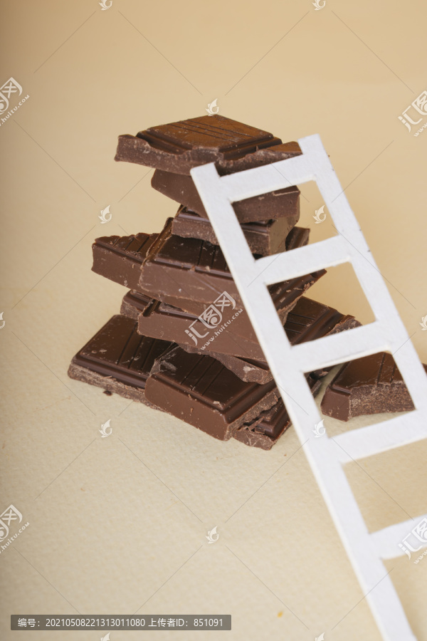 一堆破碎的黑巧克力和白色的梯子。