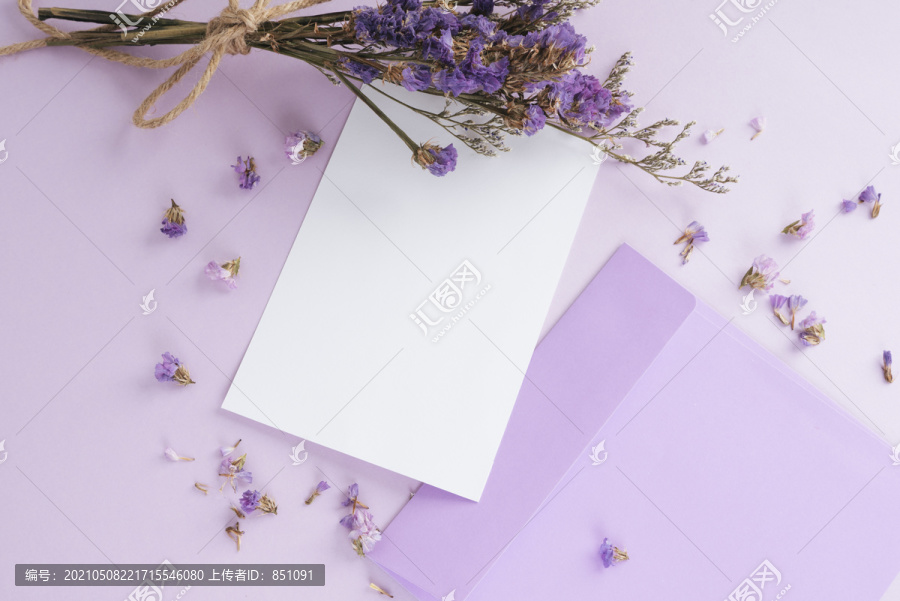 粉红色背景上有紫色花朵的模拟白纸。顶视图。