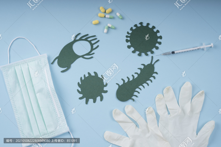 药品背景-医生面罩，手套，注射器，蓝色背景上有细菌的药丸。